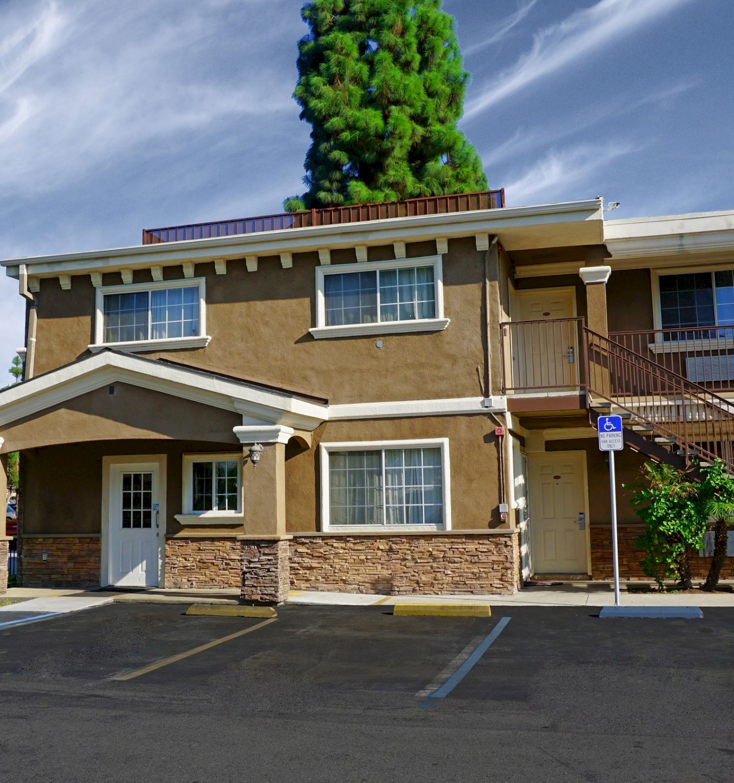 The image shows the exterior of a two-story building with a sign reading 