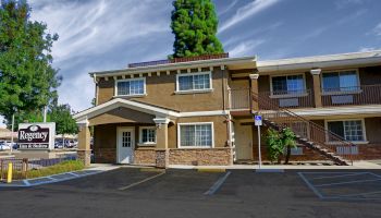 The image shows a two-story motel with a sign reading 