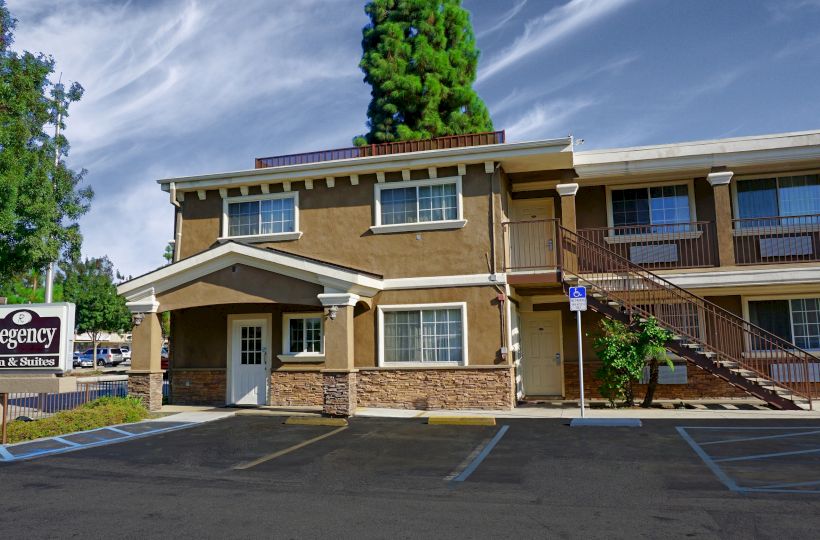 The image shows a two-story motel with a sign reading 