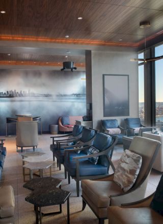 A modern lounge area with ample seating, large windows offering a scenic view of the waterfront, and contemporary decor.